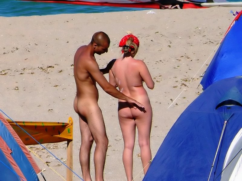 Nude people hanging out on the beach #78917404
