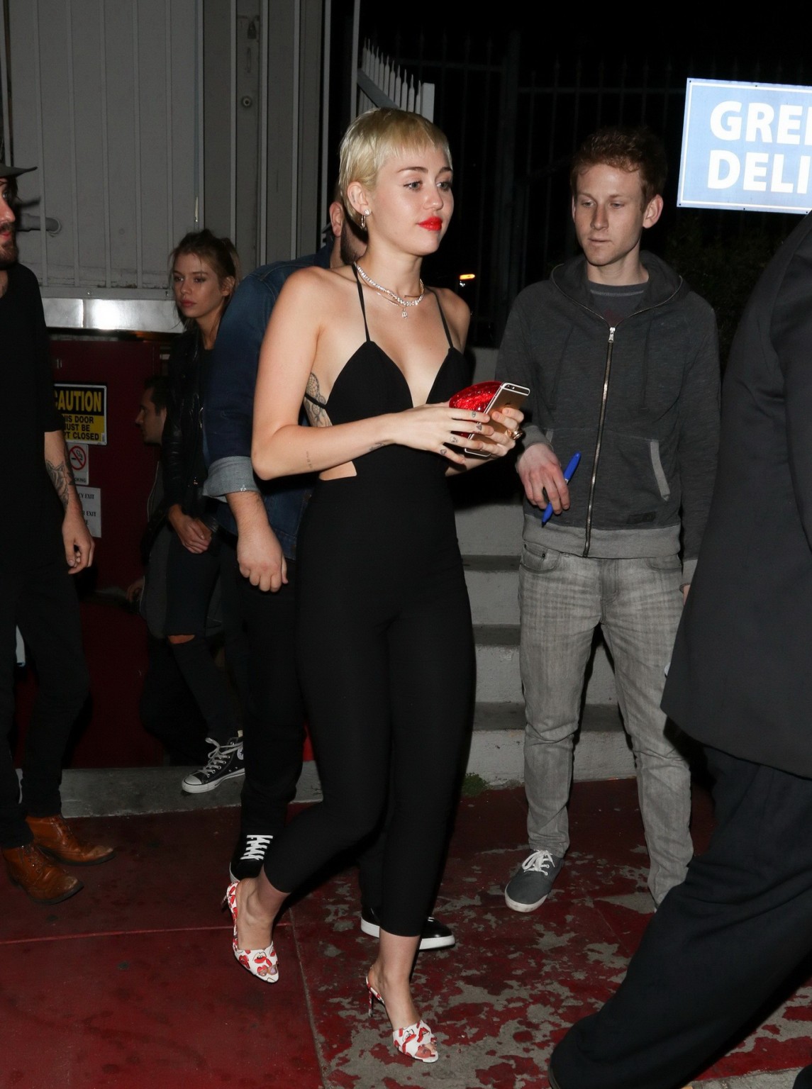Miley Cyrus braless wearing tight black bareback jumpsuit night out in Los Angel #75169385