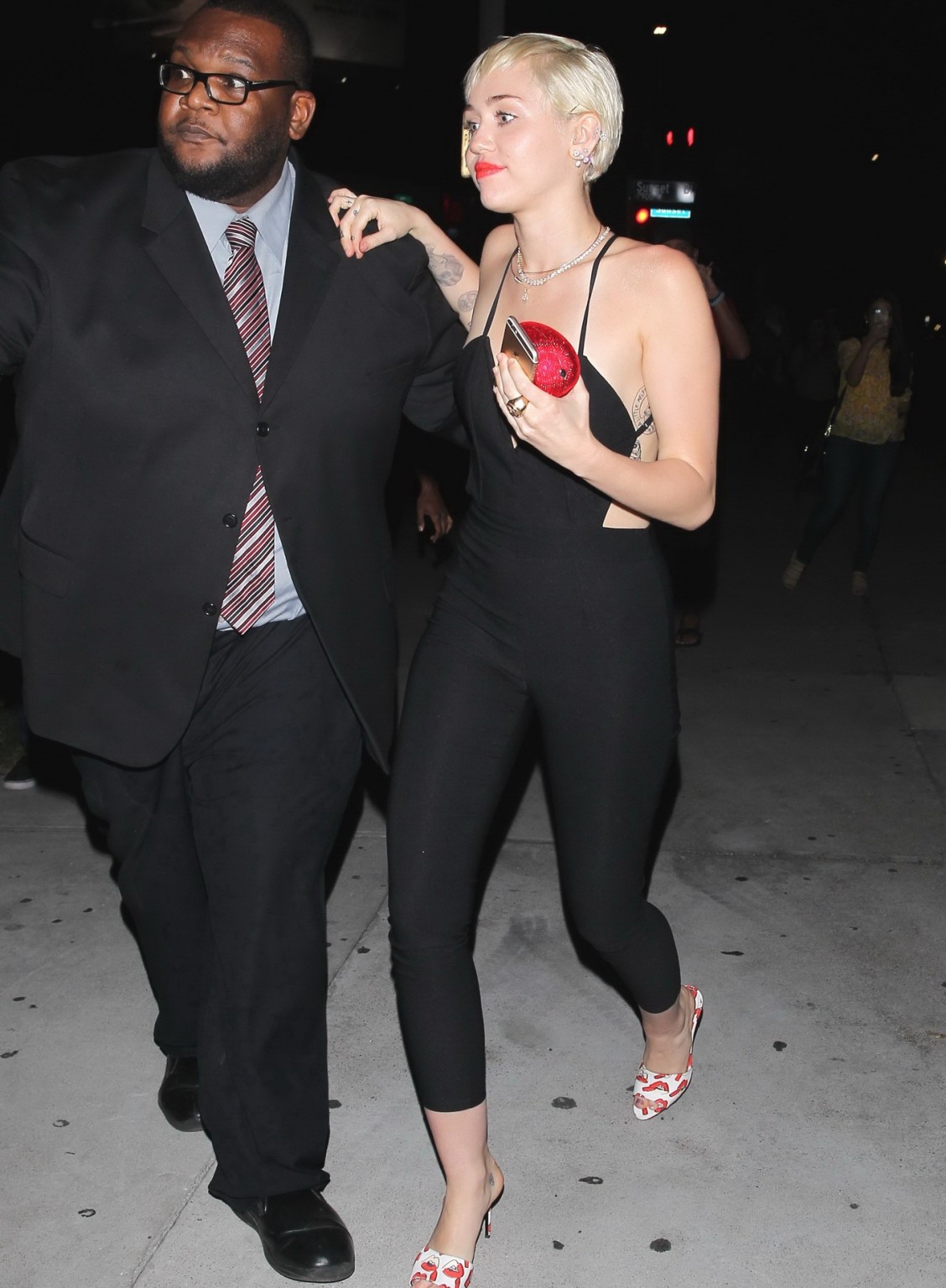 Miley Cyrus braless wearing tight black bareback jumpsuit night out in Los Angel #75169495