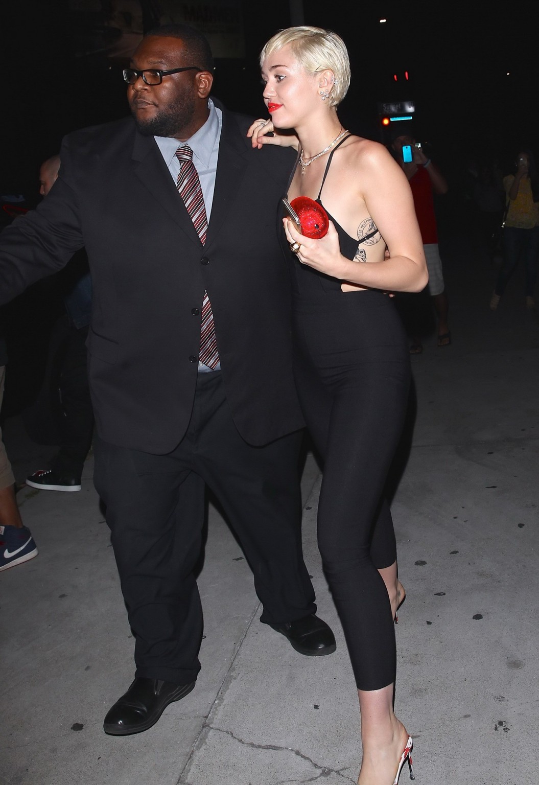 Miley Cyrus braless wearing tight black bareback jumpsuit night out in Los Angel #75169499