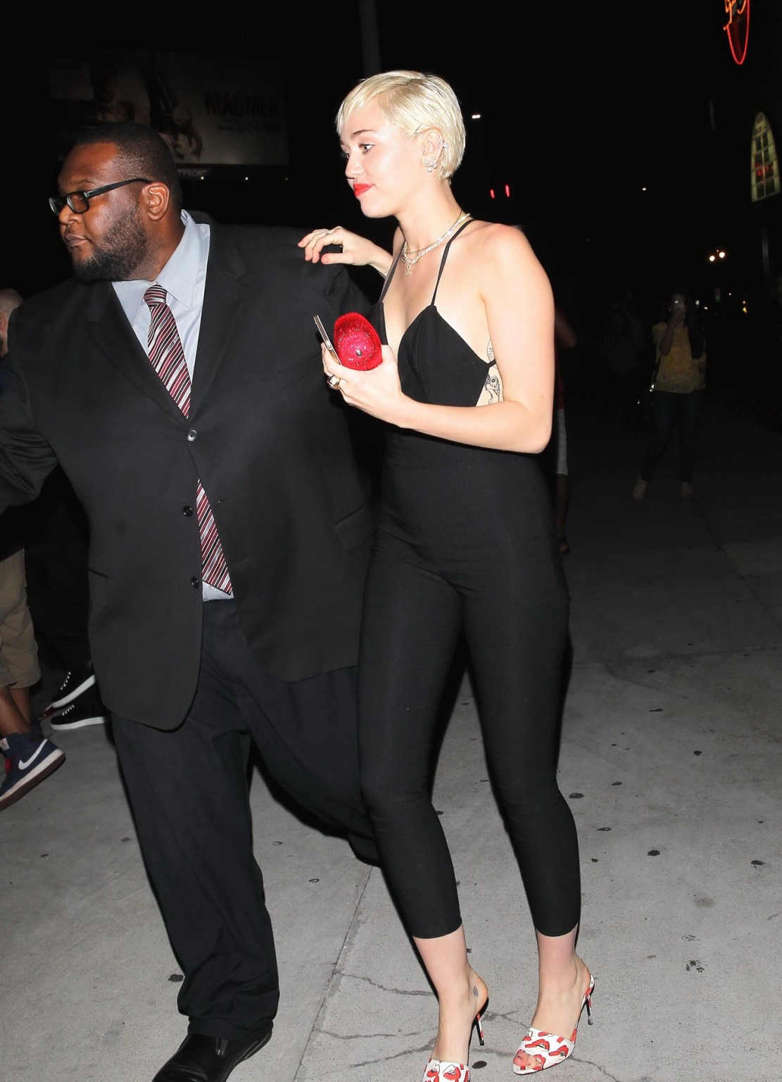 Miley Cyrus braless wearing tight black bareback jumpsuit night out in Los Angel #75169505