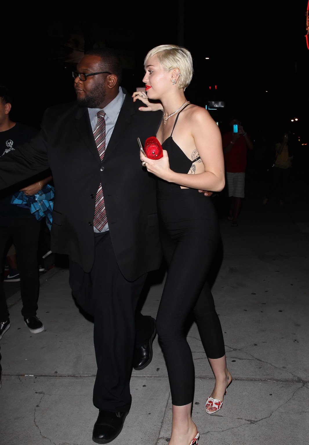 Miley Cyrus braless wearing tight black bareback jumpsuit night out in Los Angel #75169512