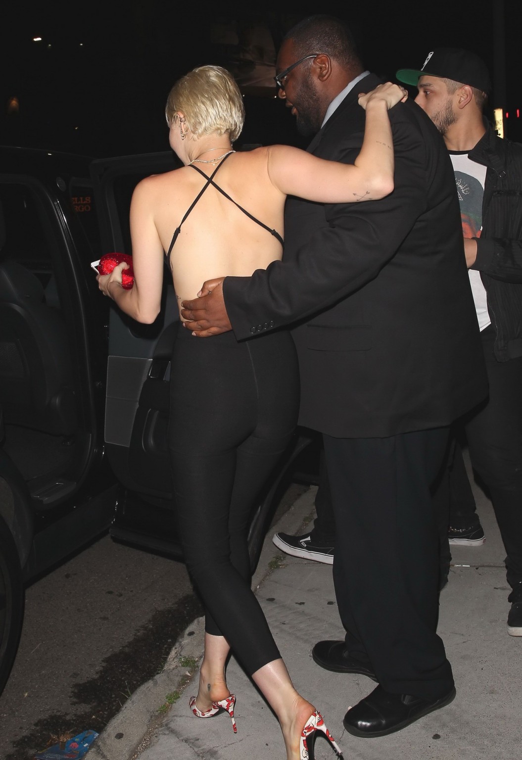 Miley Cyrus braless wearing tight black bareback jumpsuit night out in Los Angel #75169610