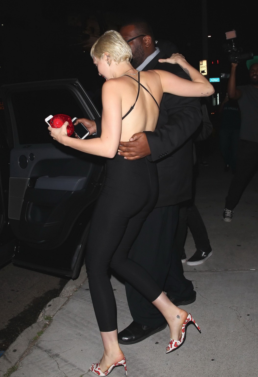 Miley Cyrus braless wearing tight black bareback jumpsuit night out in Los Angel #75169612