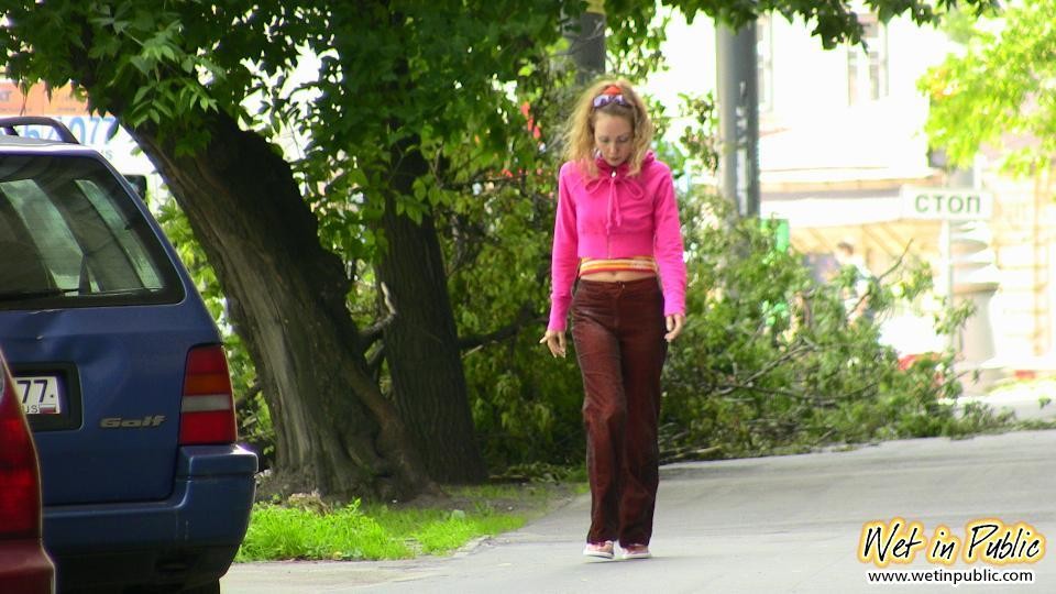 Une vilaine fille fait pipi dans son pantalon sexy derrière une voiture dans la cour.
 #73244378