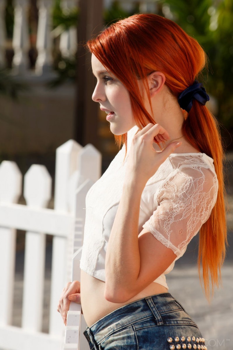 Redhead strips near a white fence #78813619