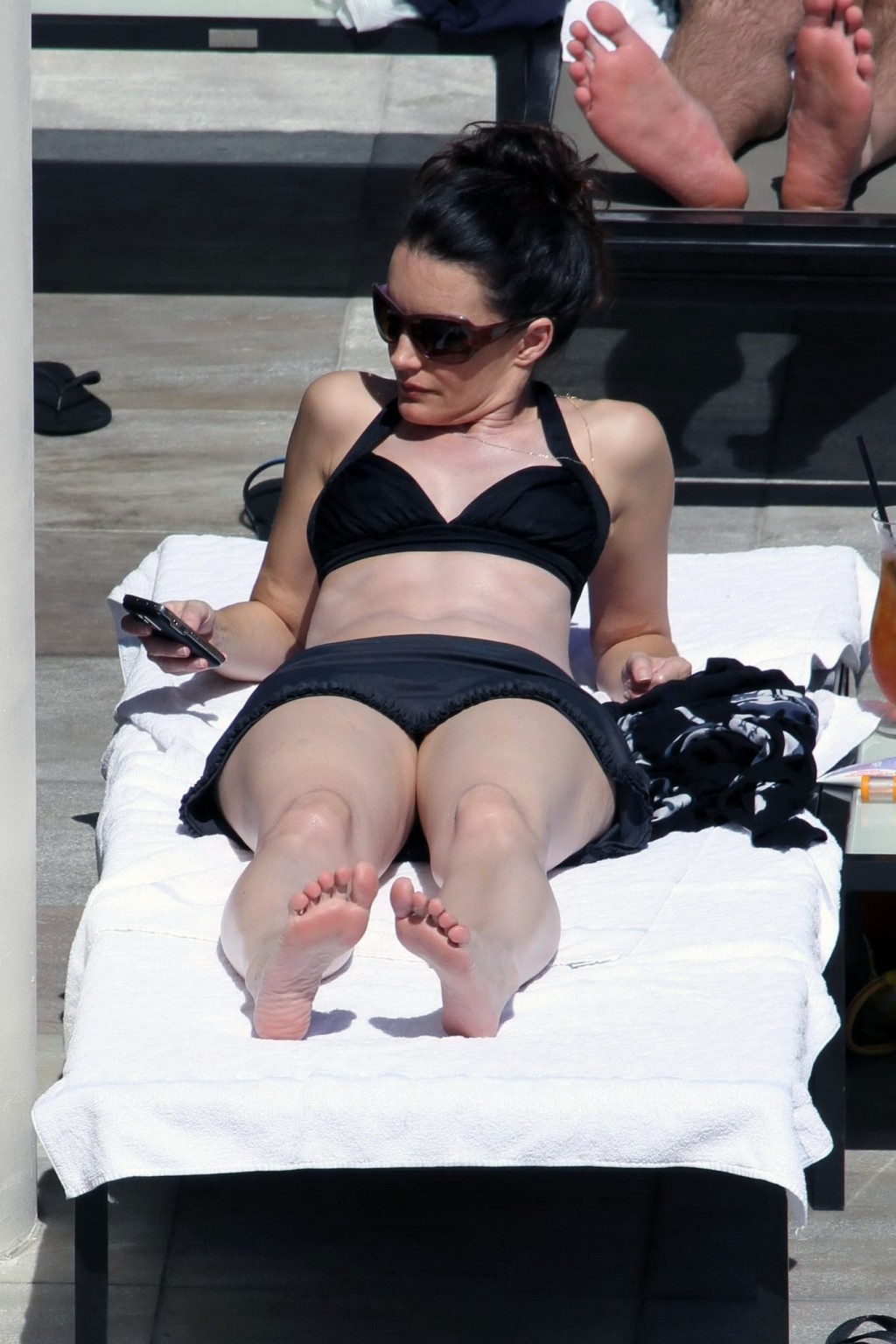 Kristin davis en mini jupe et haut de bikini noir bronzant au bord d'une piscine à hawaii
 #75328925