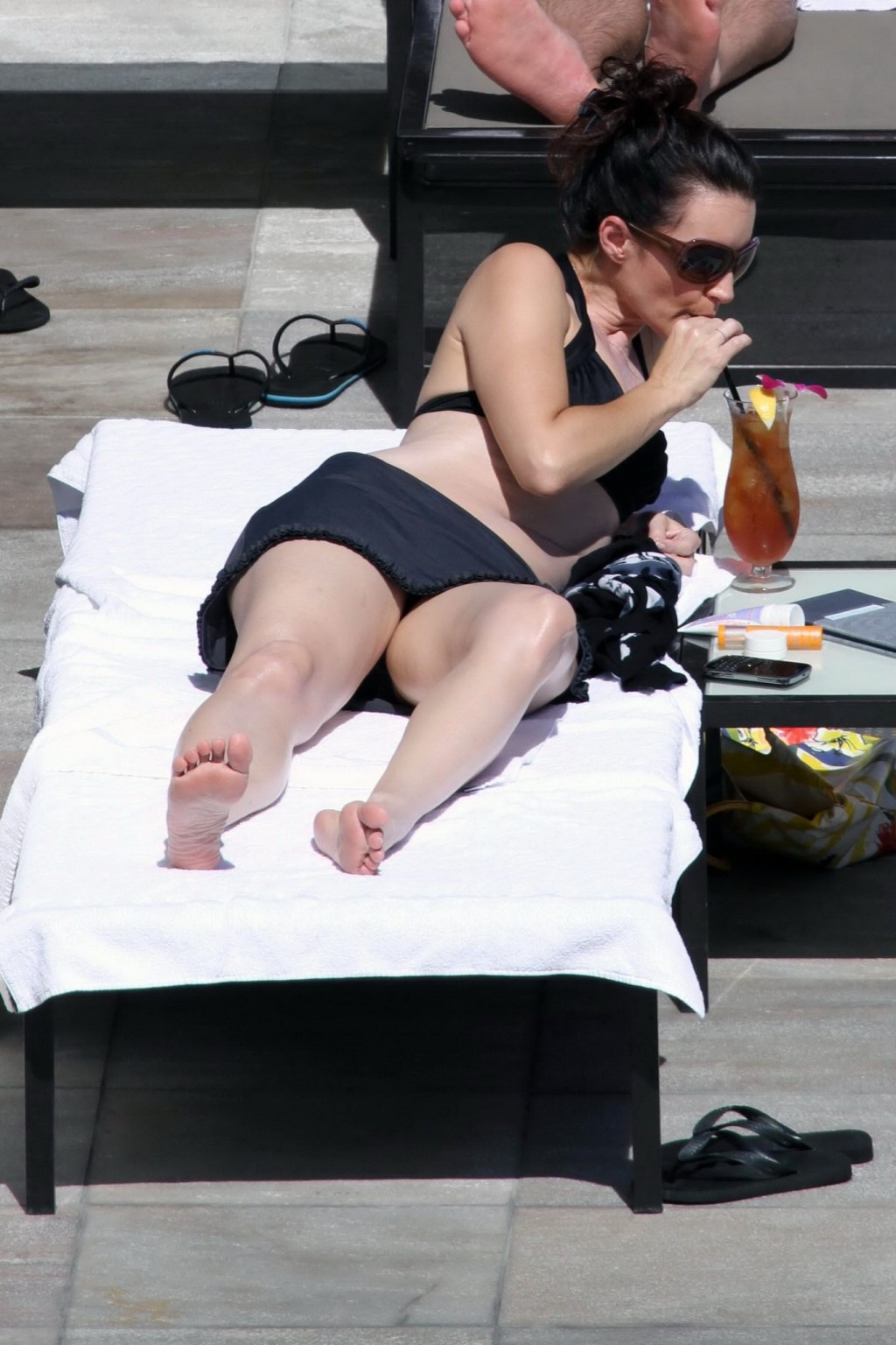 Kristin davis en mini jupe et haut de bikini noir bronzant au bord d'une piscine à hawaii
 #75328991