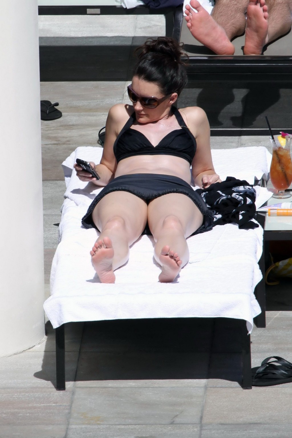 Kristin davis en mini jupe et haut de bikini noir bronzant au bord d'une piscine à hawaii
 #75329004