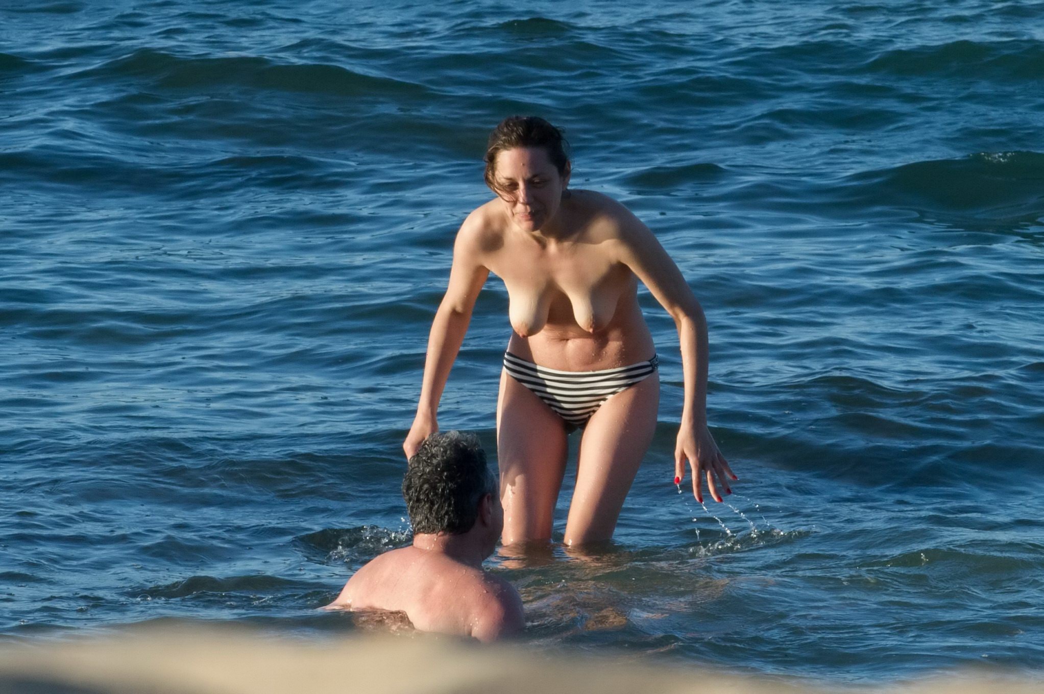 Marion cotillard se baignant seins nus à la plage
 #75141731