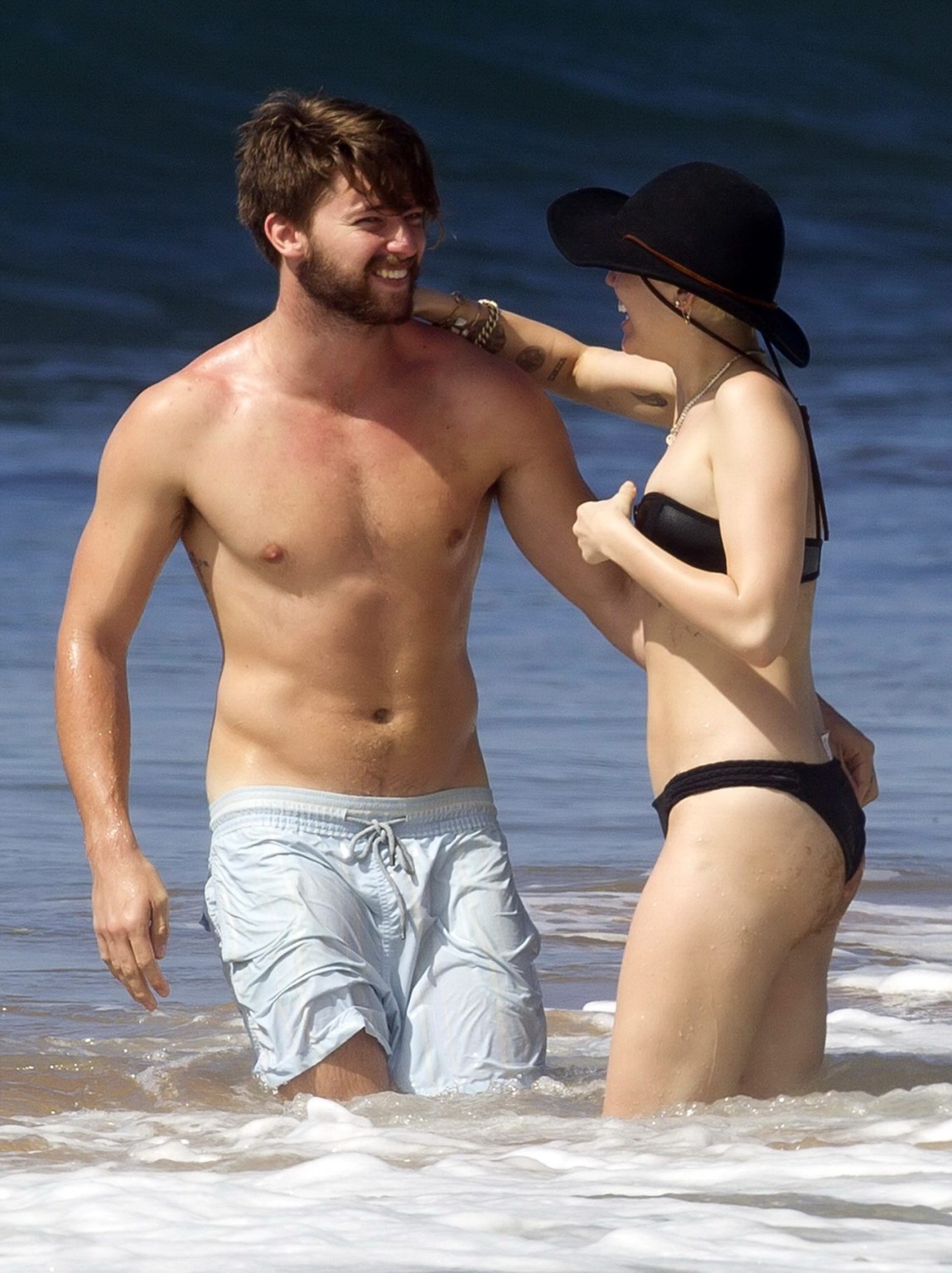 Miley Cyrus showing off her bikini body and getting her ass groped on a Hawaiian