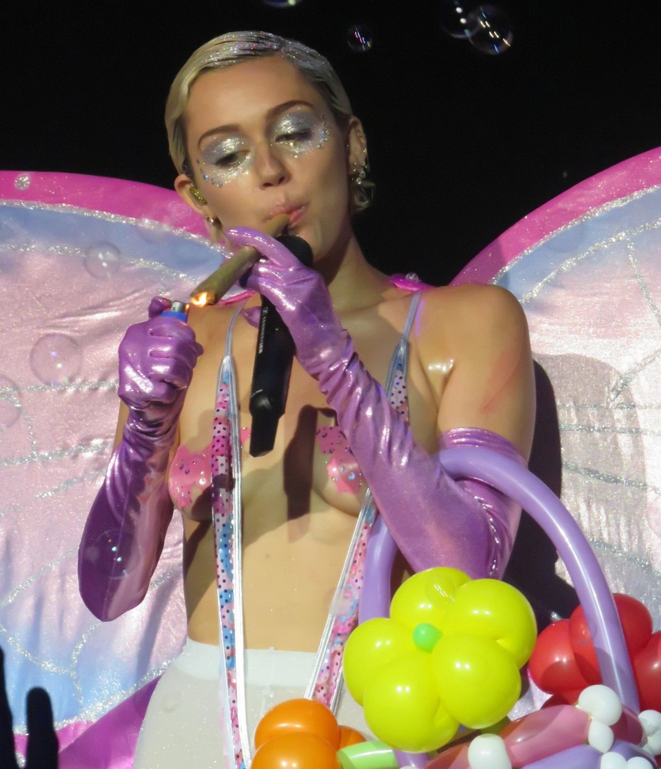 Miley Cyrus, seins nus, portant des collants et une culotte papillon lors d'un concert au festival de Cannes. 
 #75164657