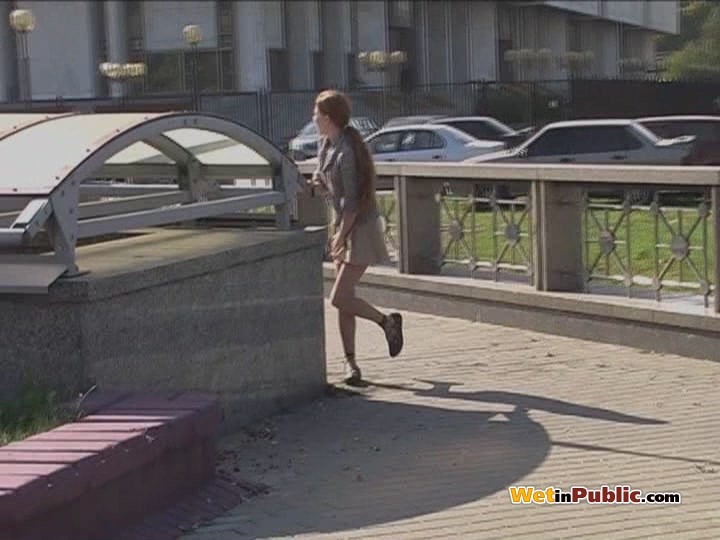 Una chica desconcertada salpica su falda y sus piernas con pis en la calle
 #78595035