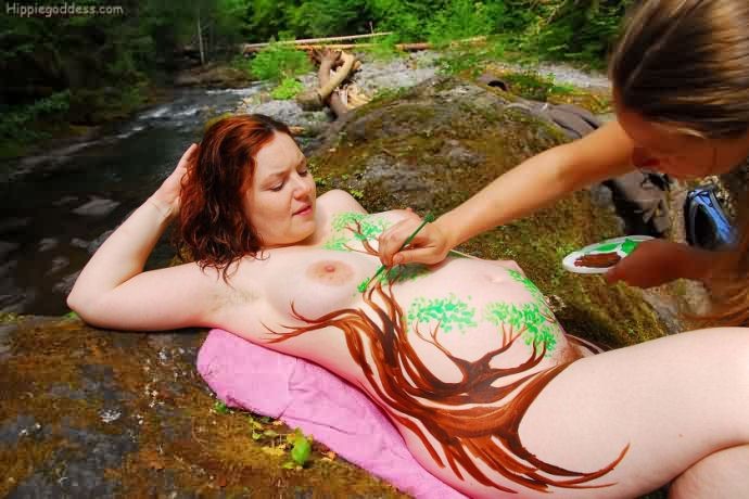 ボディーペイントをした毛深い妊婦のヌーディストが川岸で裸になる
 #75570805