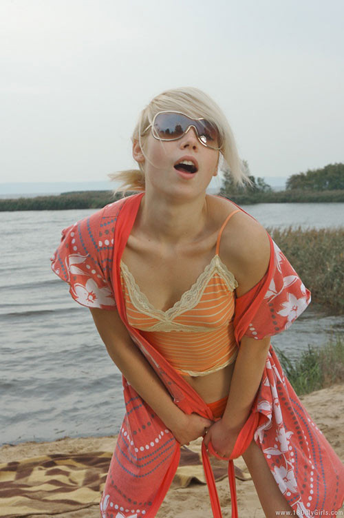 Adorable jeune blonde aux petits seins posant nue sur la plage
 #73903161