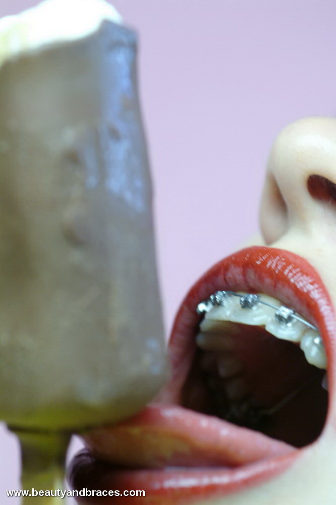 歯列矯正をしたブルネットのティーンがアイスキャンディーで汚す
 #73259330