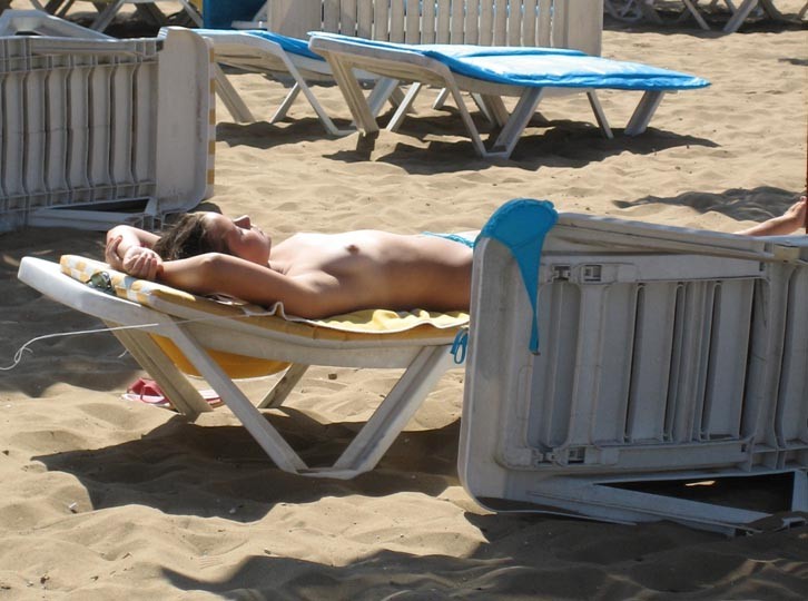 Junge Nudistin zeigt ihren schlanken Körper am Strand
 #72250742