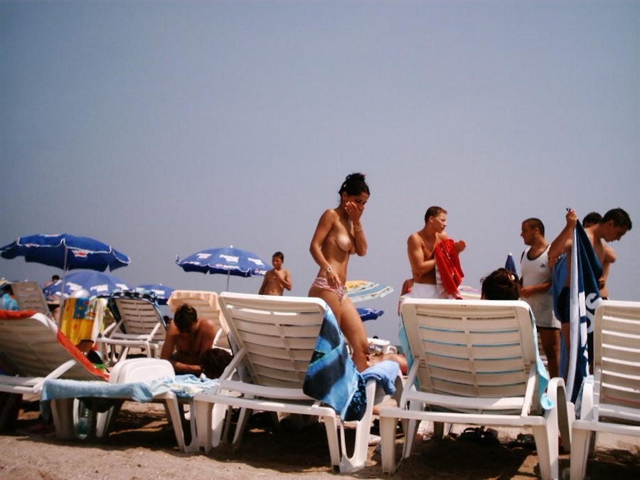 Junge Nudistin zeigt ihren schlanken Körper am Strand
 #72250781