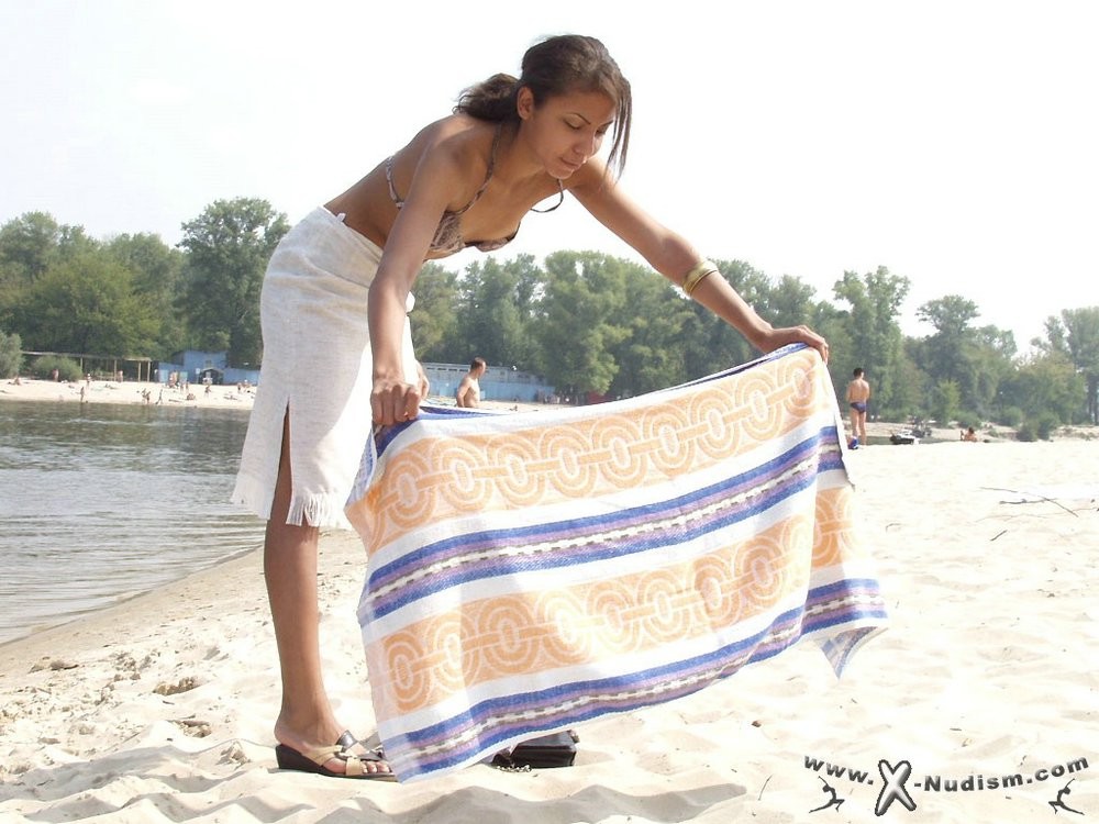 Une jeune nudiste montre son corps mince à la plage.
 #72701258