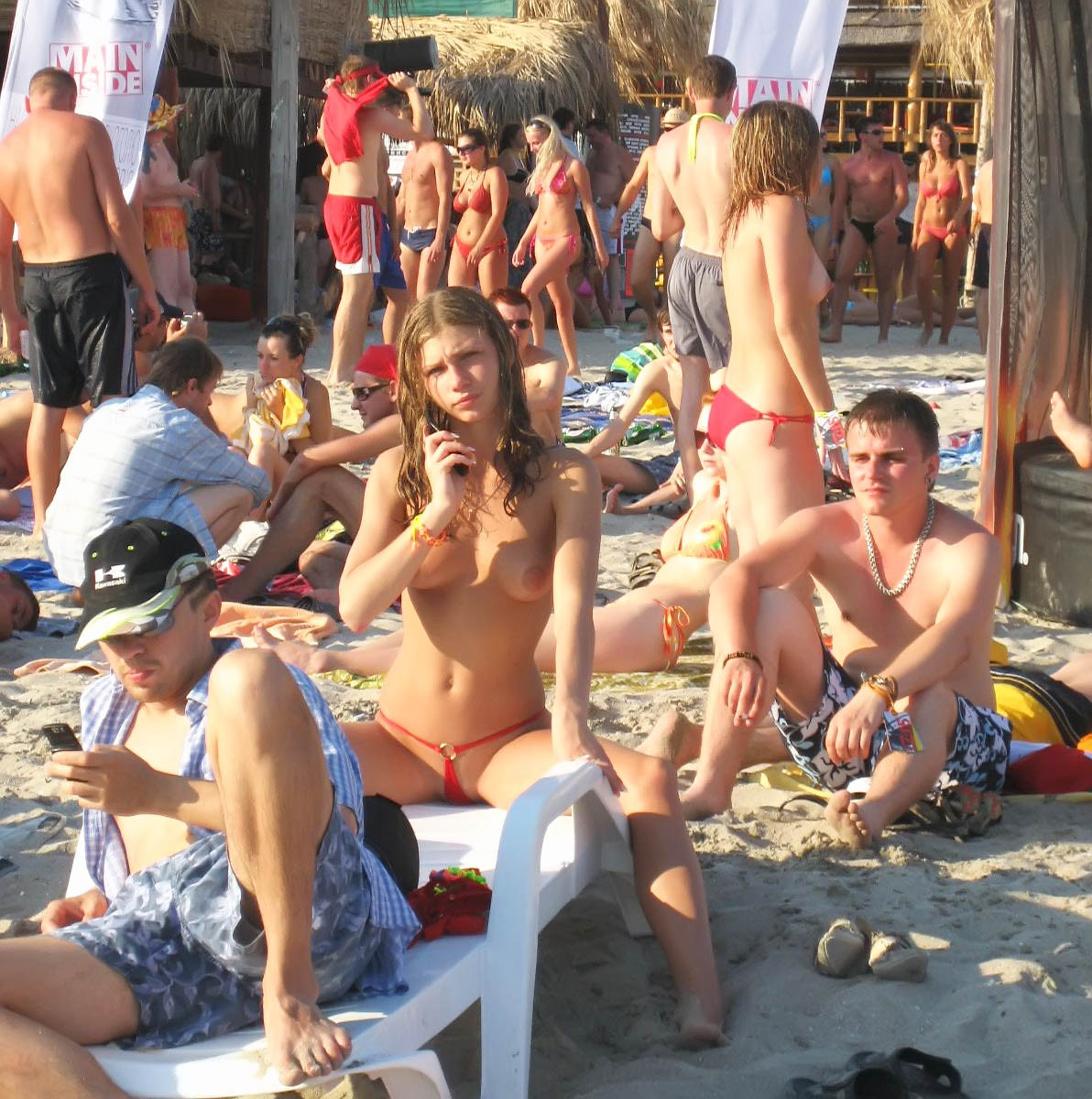 Jeunes nus jouant ensemble sur une plage publique
 #70273383