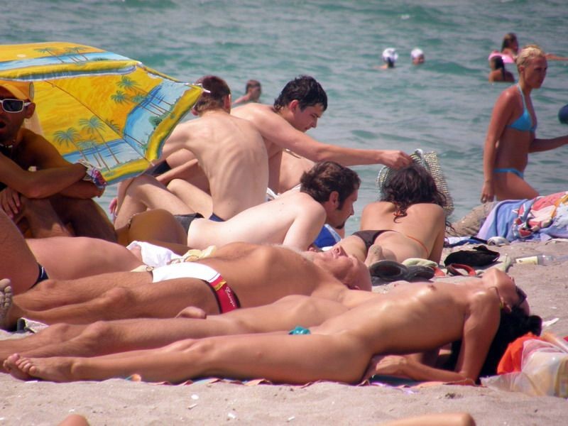 Des jeunes nudistes enlèvent leurs vêtements et jouent nus.
 #72256201