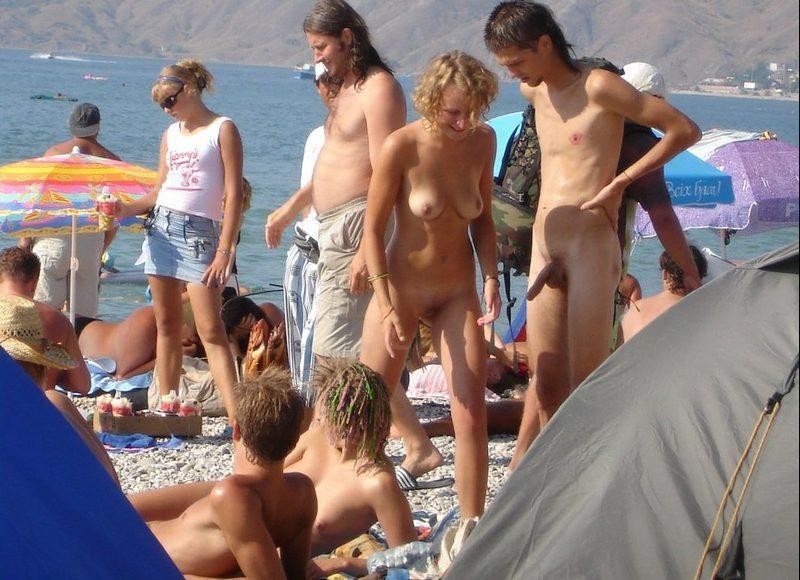 Des jeunes nudistes enlèvent leurs vêtements et jouent nus.
 #72256223