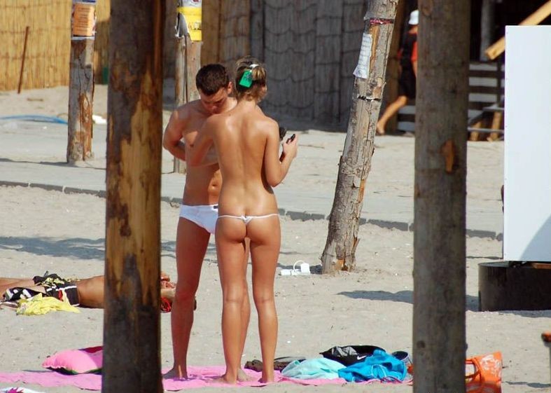 Des jeunes nudistes enlèvent leurs vêtements et jouent nus.
 #72256237