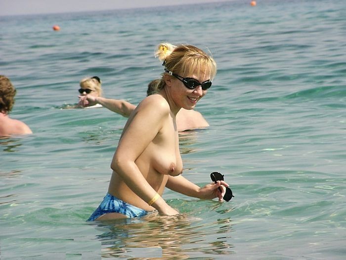 Une jeune sexy choque la plage en se déshabillant.
 #72248397