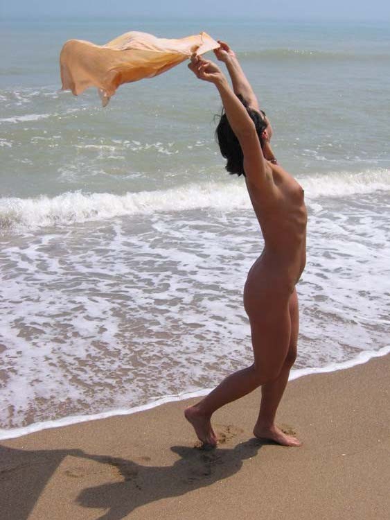 Une jeune sexy choque la plage en se déshabillant.
 #72248484