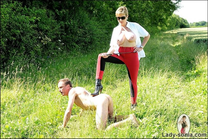 A busty whip mistress is abusing her male slave in the open #72198210