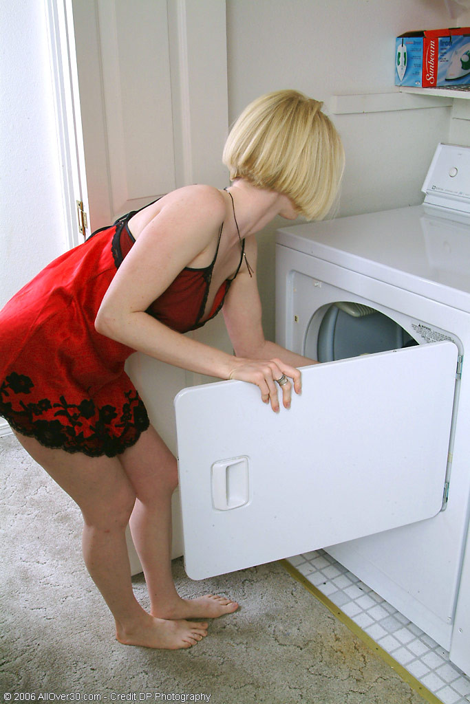 Une blonde a chaud en faisant la lessive, alors elle se déshabille.
 #67545860