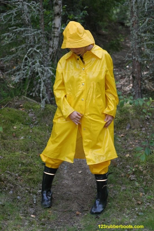 Chica sexy con botas de goma y ropa de lluvia amarilla
 #73286029