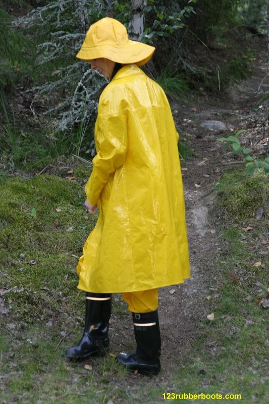 Ragazza sexy con stivali di gomma e abbigliamento da pioggia giallo
 #73286044