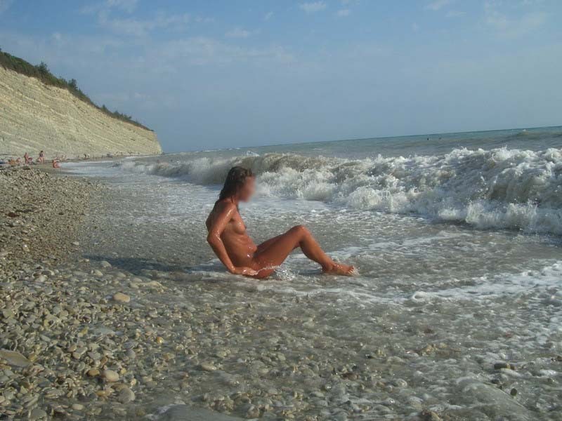 Une nana aux gros seins montre son corps nu à la plage nudiste.
 #72253004
