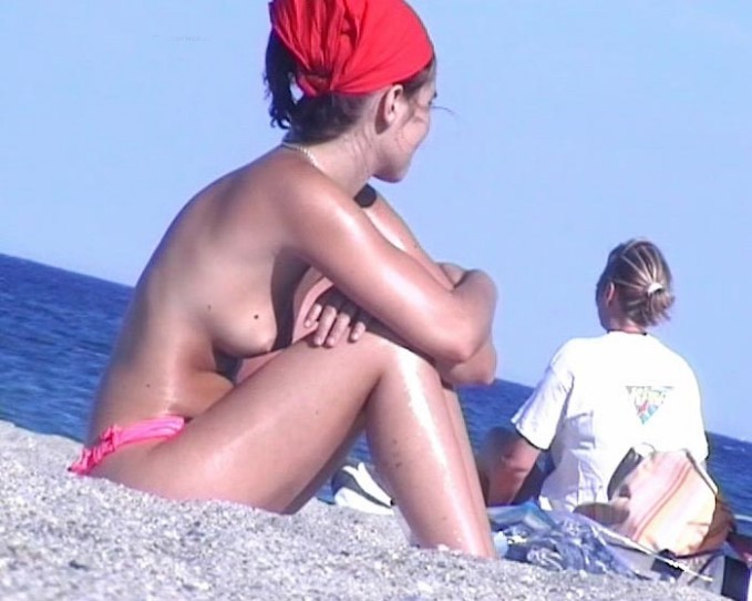 Una ragazza tettona mostra il suo corpo nudo sulla spiaggia nudista
 #72253130