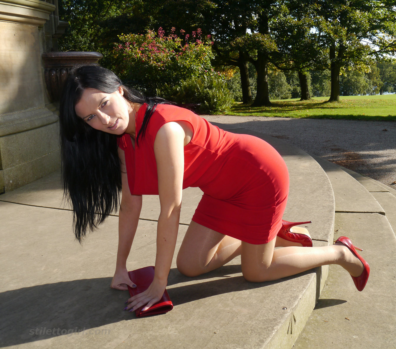 Une femme sexy fétichiste des chaussures se promène à l'extérieur dans une robe rouge moulante avec des talons hauts.
 #74637415
