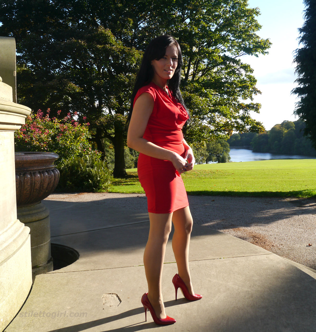 Une femme sexy fétichiste des chaussures se promène à l'extérieur dans une robe rouge moulante avec des talons hauts.
 #74637578