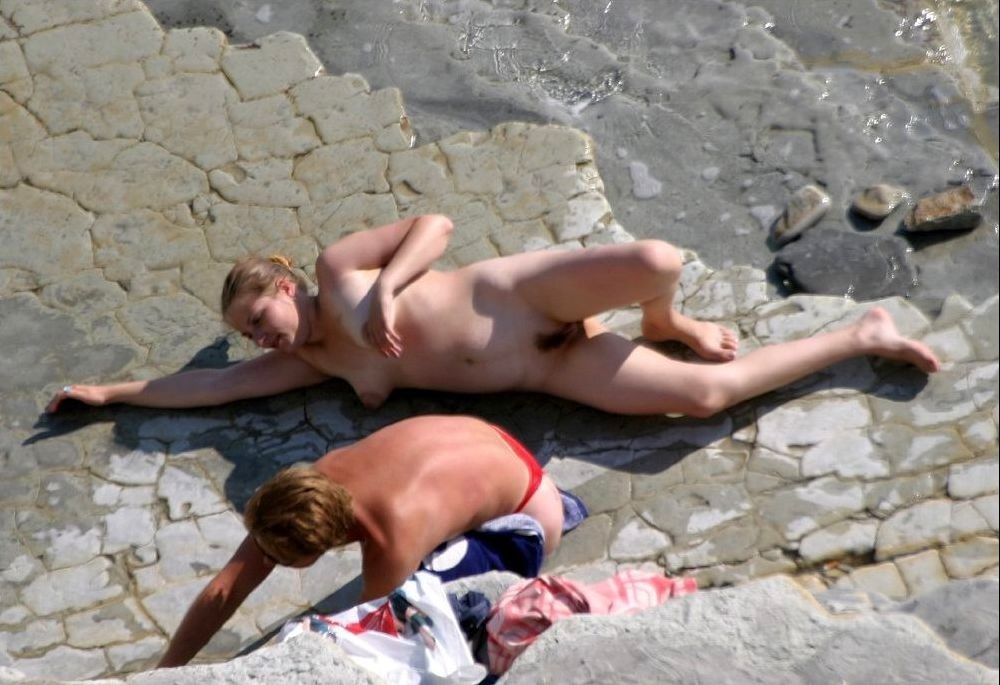 Guarda una ragazza nuda in spiaggia che abbronza il suo corpo caldo
 #72252005