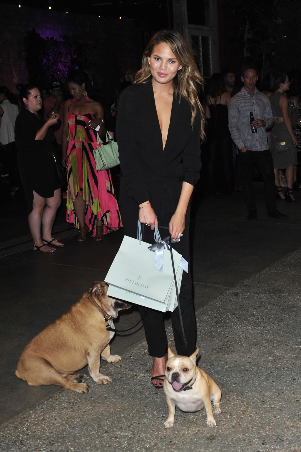 Chrissy Teigen braless  cleavy petting two ugly bulldogs at the new Piperlime co #75184339