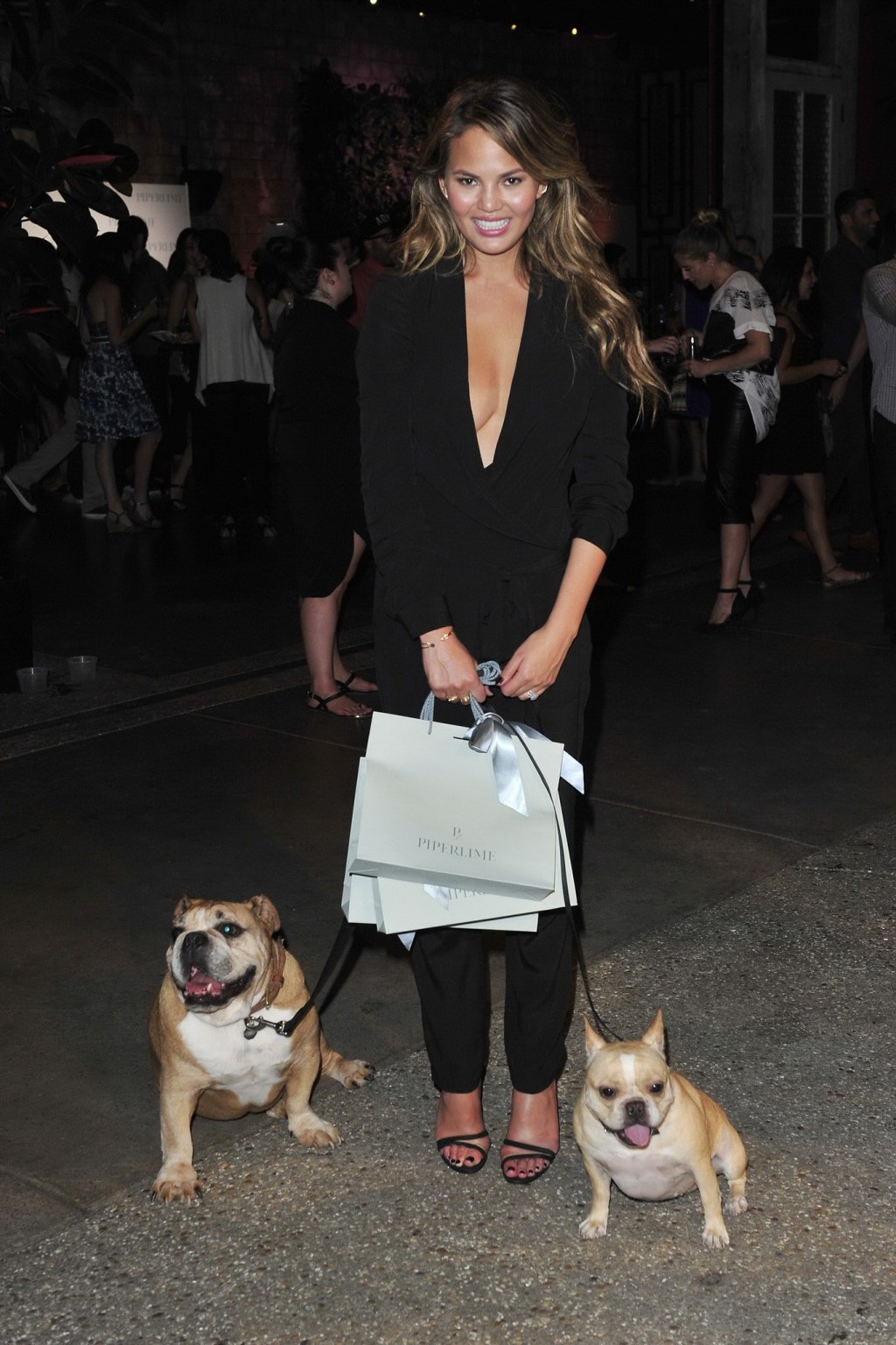 Chrissy Teigen braless  cleavy petting two ugly bulldogs at the new Piperlime co #75184343