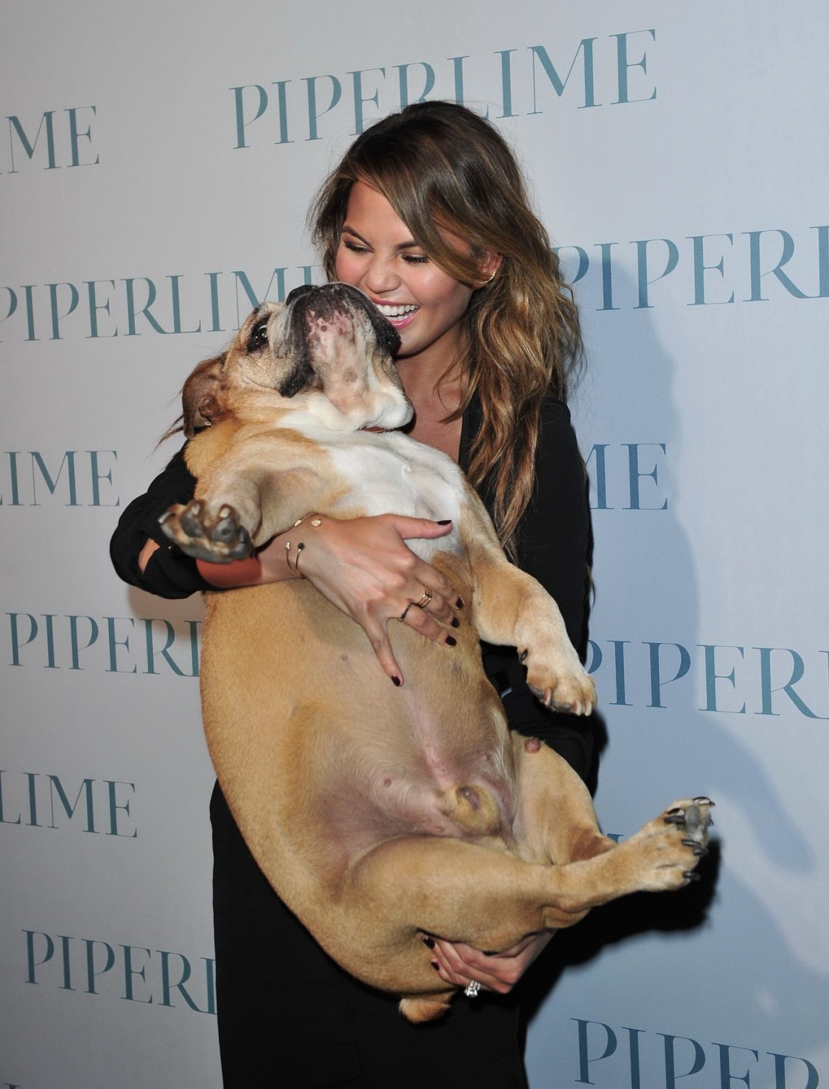 Chrissy Teigen braless  cleavy petting two ugly bulldogs at the new Piperlime co #75184368