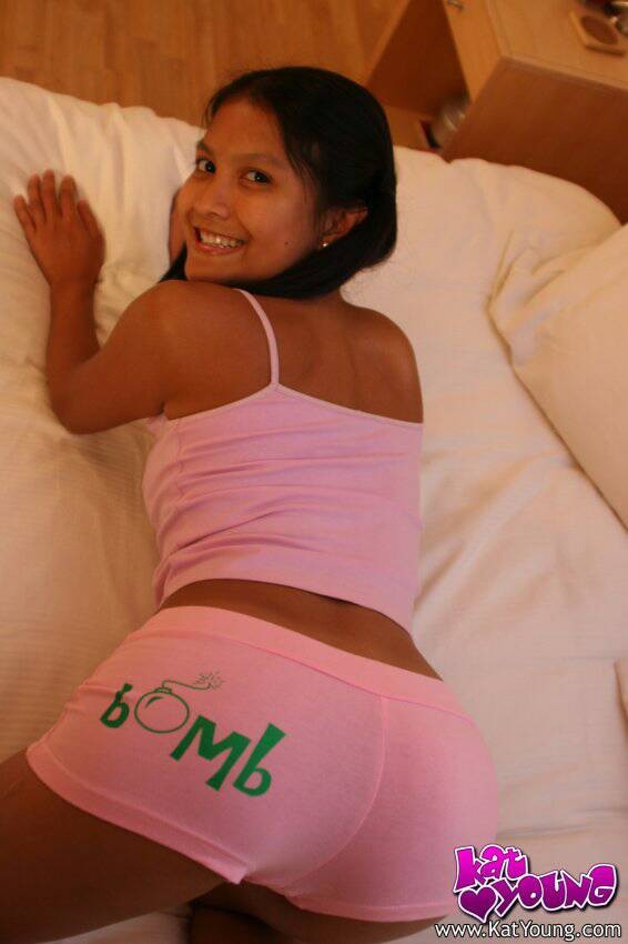 Kat Young poses in pink shorts on her bed #67765164