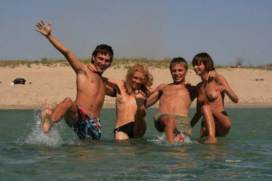 Une jeune nudiste mince fume pendant une chaude journée d'été.
 #72255904