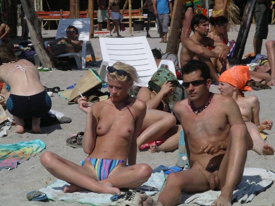 Des jeunes nudistes aux gros seins et minces s'allongent au soleil.
 #72254337