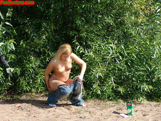 Blonde teen peeing on the river beach #78616424
