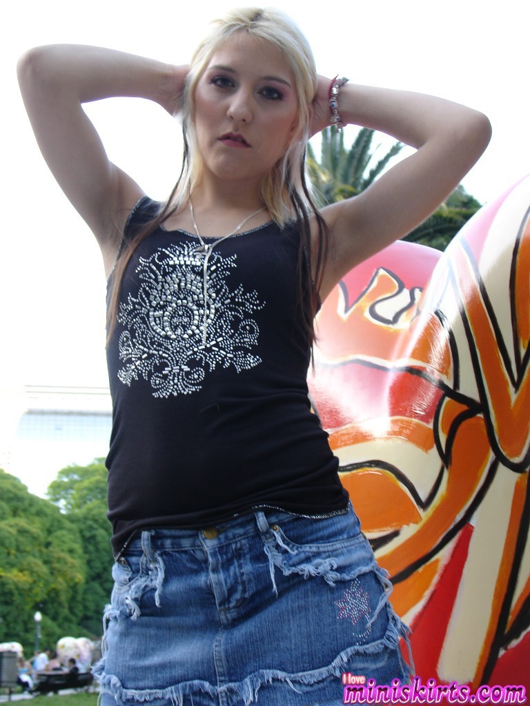 Blonde in black boots and tight blue jeans mini skirt posing outdoors #70079392