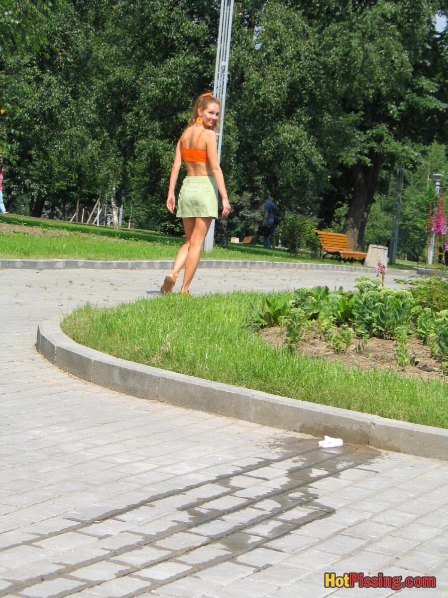 Babe in green and orange sits down on a border and does a piss coolly #76525691