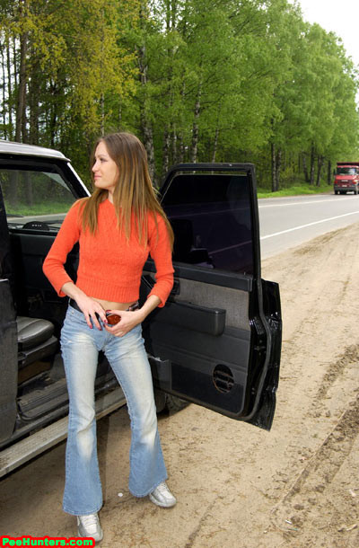 Bella ragazza che piscia vicino alla sua auto dopo un lungo viaggio
 #78695011