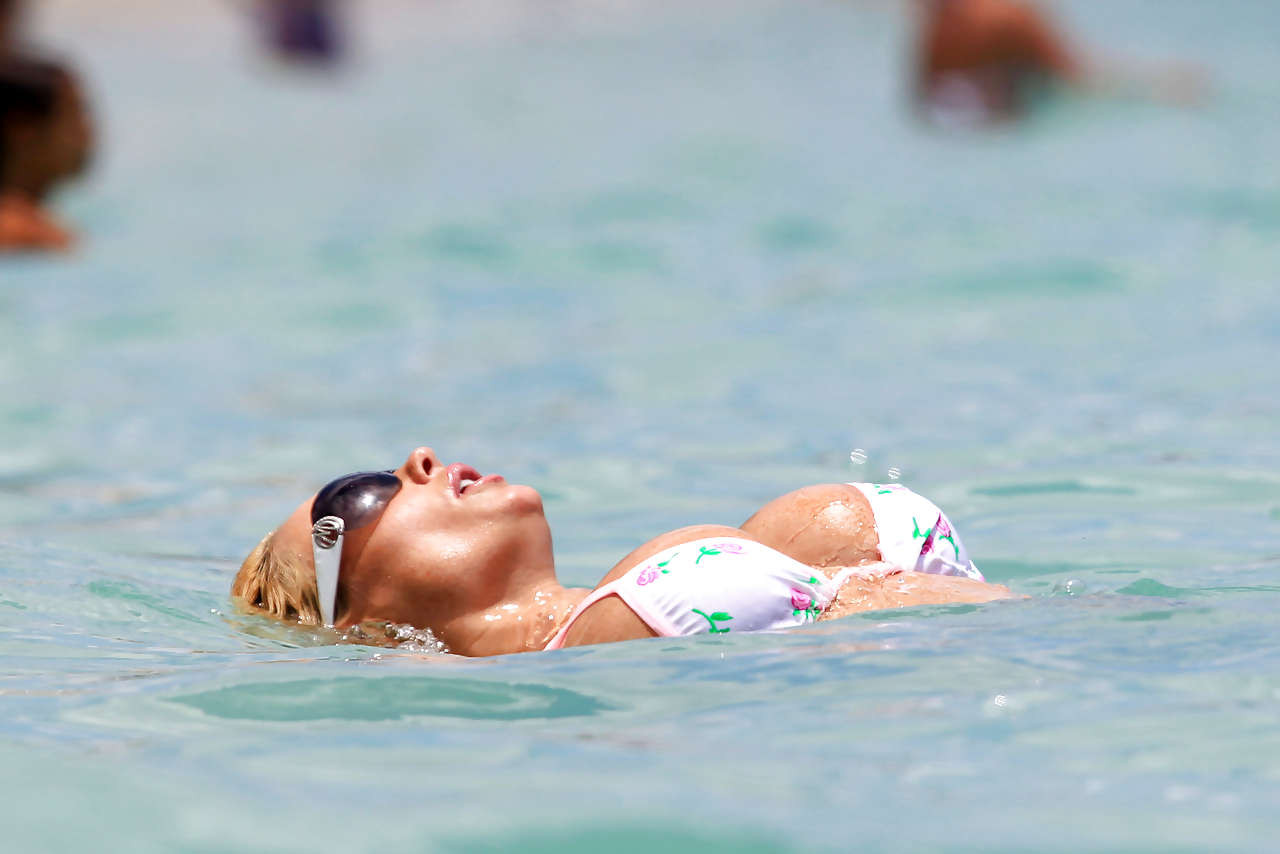 Nicole Coco Austin en bikini et montrant son gros cul dans un minuscule string sur la plage.
 #75295600