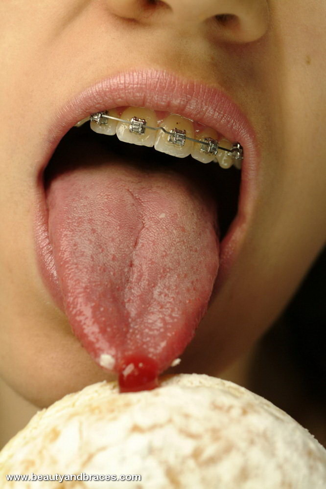 Une jeune avec une queue de cochon et un appareil dentaire enfonce un beignet dans sa bouche sexy.
 #74900309